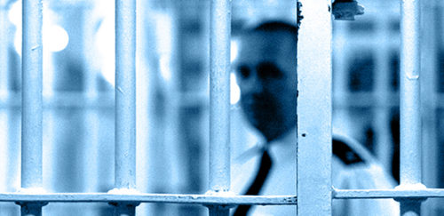 Close up of prison guard through bars looking at prison law meeting